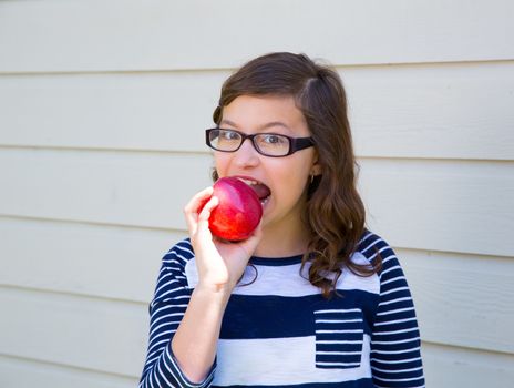 Teenager girl happy eating a red apple