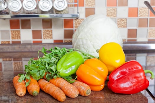 Fresh vegetables lie on a kitchen table