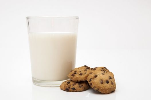 glass of milk and chocolate chip cookies on a white background