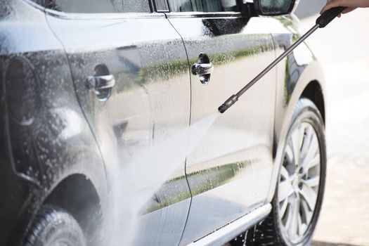 closeup of a car and a pressure washer