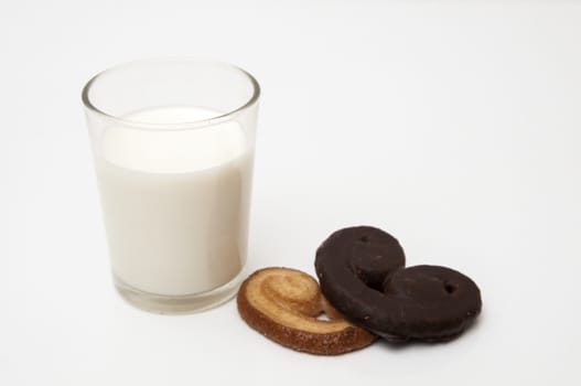 glass of milk with heart shaped cookies on a white background