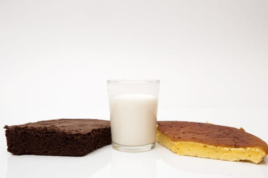 glass of milk with different cakes on a white background