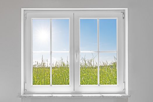 picture of a white wall with white closed window indoor and outside green meadow with sun and blue sky