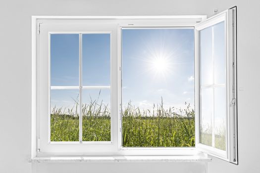 picture of a white wall with white half open window indoor and outside green meadow with sun and blue sky