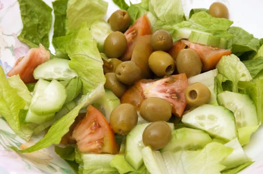 green salad with lettuce, tomatoes, onions and olives