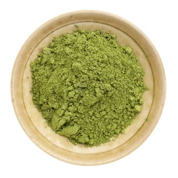 moringa leaf powder in a small ceramic bowl, isolated on white, top view