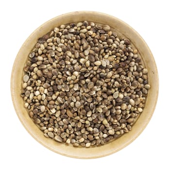 whole hemp seeds in a small bowl isolated on white, top view