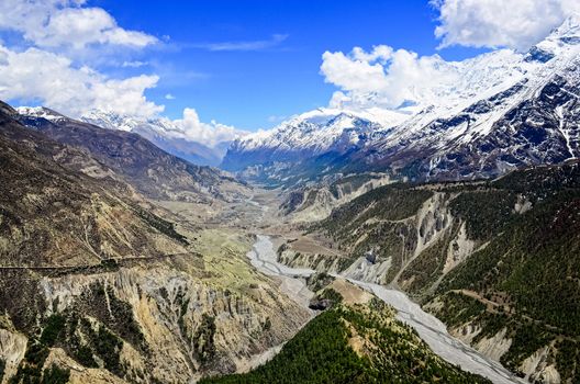 Himalayas mountains river valley, white peaks and Manang village in background