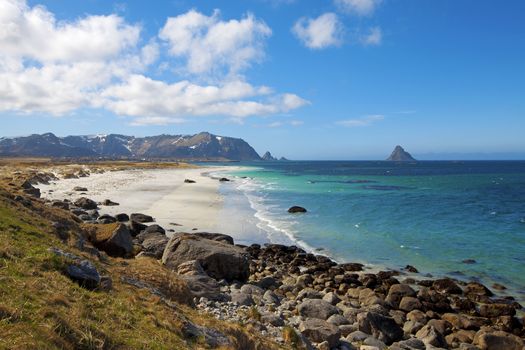 White beach, snowcapped mountains and blue water, Norwegian fjord