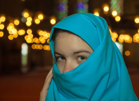 Teen muslim girl covered with hijab at a mosque