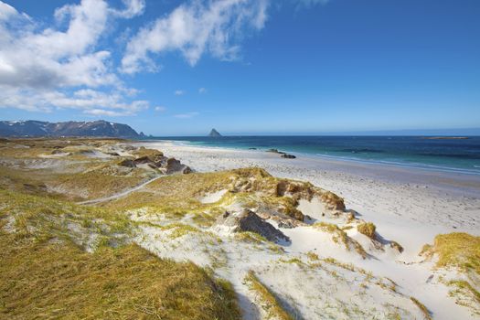 White beach, snowcapped mountains and blue water, Norwegian fjord