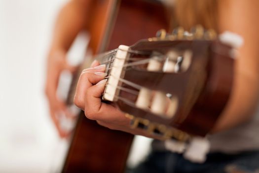 Closeup image of guitar in caucasian woman hands