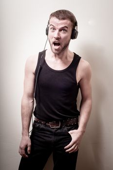 hipster stylish fashion blonde man with headphones on gray background