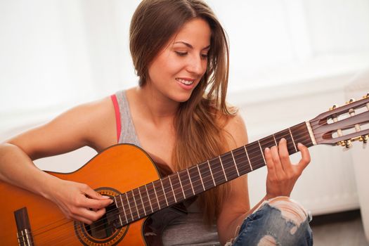 Young beautiful caucasian woman in casual playing guitar