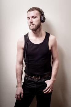 hipster stylish fashion blonde man with headphones on gray background