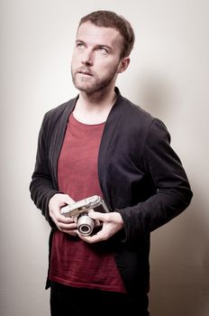 hipster stylish fashion man with old camera on gray background