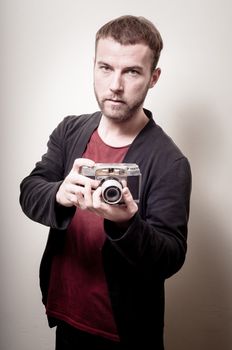 hipster stylish fashion man with old camera on gray background