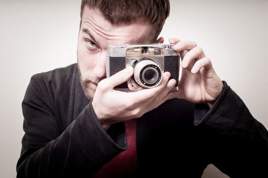 hipster stylish fashion man with old camera on gray background
