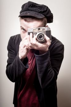 hipster stylish fashion man with old camera on gray background
