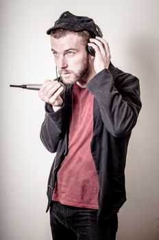 hipster stylish fashion blonde man with headphones on gray background