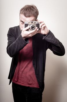 hipster stylish fashion man with old camera on gray background