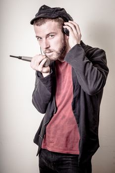 hipster stylish fashion blonde man with headphones on gray background