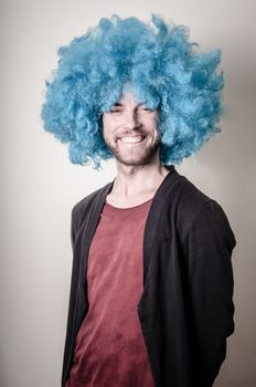 hipster stylish funny man with blue wig on gray background