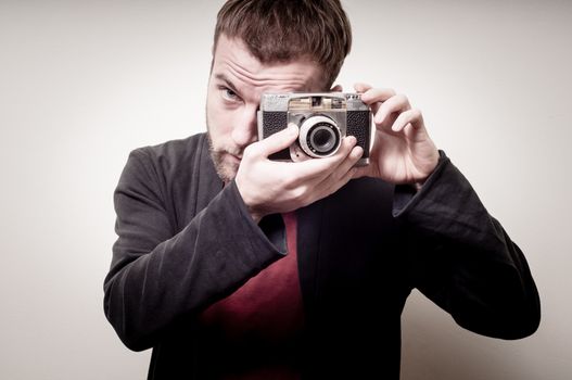 hipster stylish fashion man with old camera on gray background