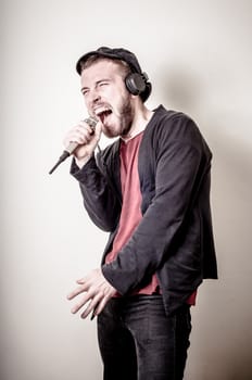 hipster stylish fashion blonde man with headphones on gray background