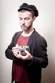 hipster stylish fashion man with old camera on gray background