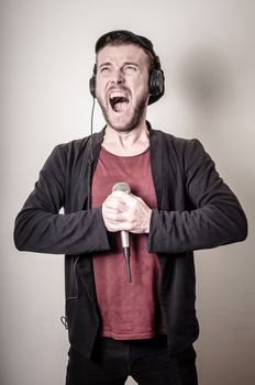hipster stylish fashion blonde man with headphones on gray background