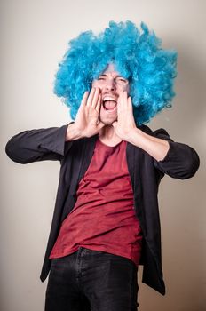 hipster stylish funny man with blue wig on gray background