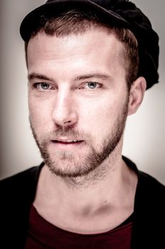 portrait closeup of hipster modern stylish blonde man on gray background