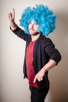 hipster stylish funny man with blue wig on gray background