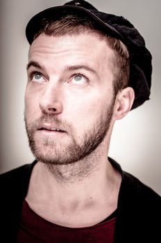 portrait closeup of hipster modern stylish blonde man on gray background