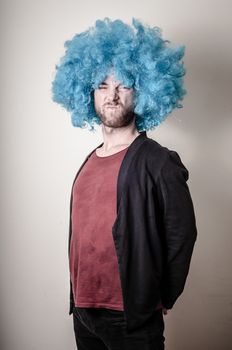 hipster stylish funny man with blue wig on gray background