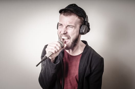hipster stylish fashion blonde man with headphones on gray background