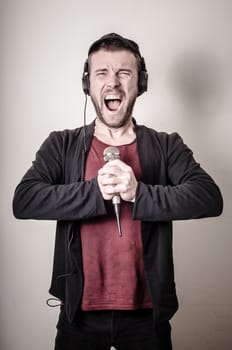 hipster stylish fashion blonde man with headphones on gray background