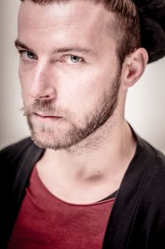 portrait closeup of hipster modern stylish blonde man on gray background