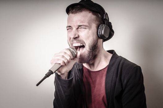 hipster stylish fashion blonde man with headphones on gray background