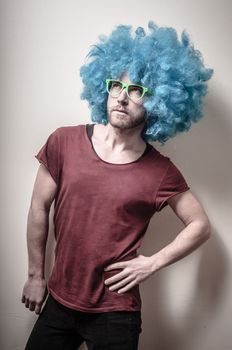 hipster stylish funny man with blue wig on gray background