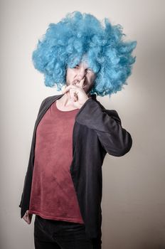 hipster stylish funny man with blue wig on gray background