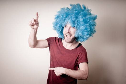 hipster stylish funny man with blue wig on gray background