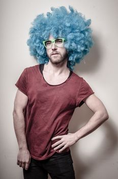 hipster stylish funny man with blue wig on gray background