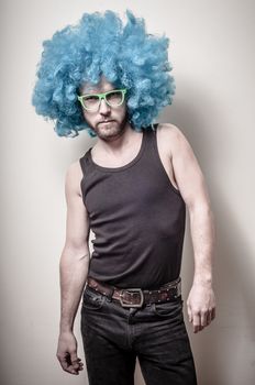 hipster stylish funny man with blue wig on gray background