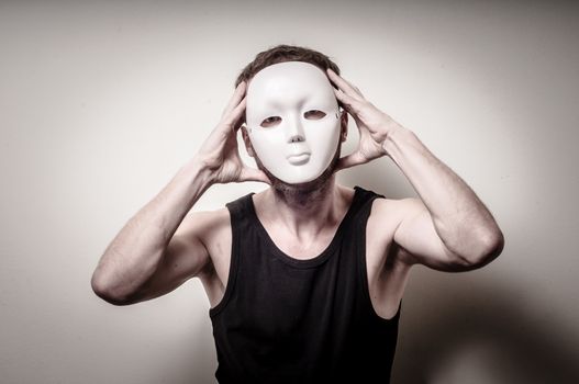 man with white mask on gray background
