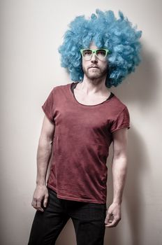hipster stylish funny man with blue wig on gray background