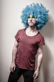 hipster stylish funny man with blue wig on gray background