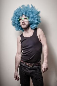 hipster stylish funny man with blue wig on gray background