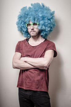 hipster stylish funny man with blue wig on gray background